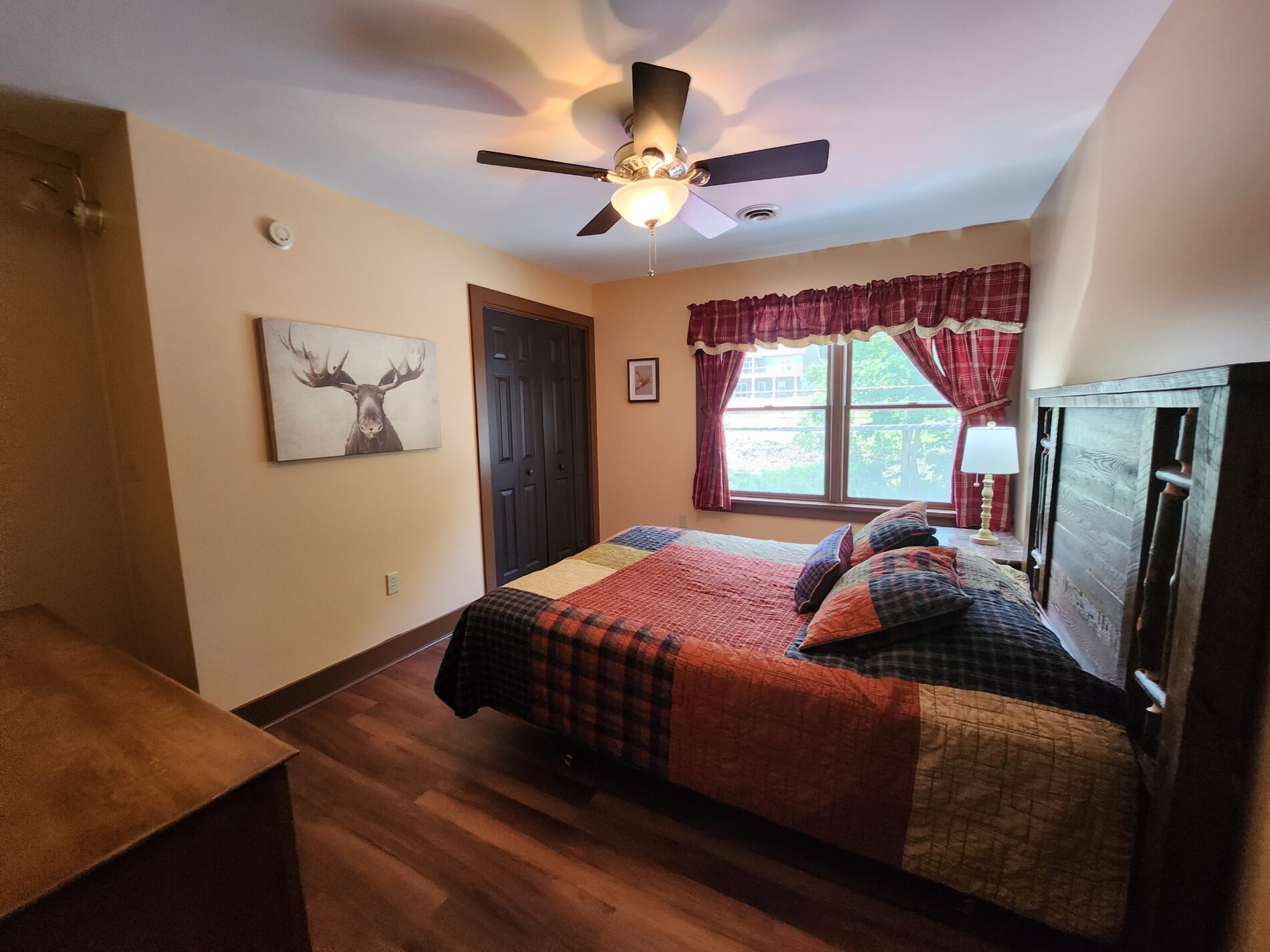 bed with bedspread and moose art on wall